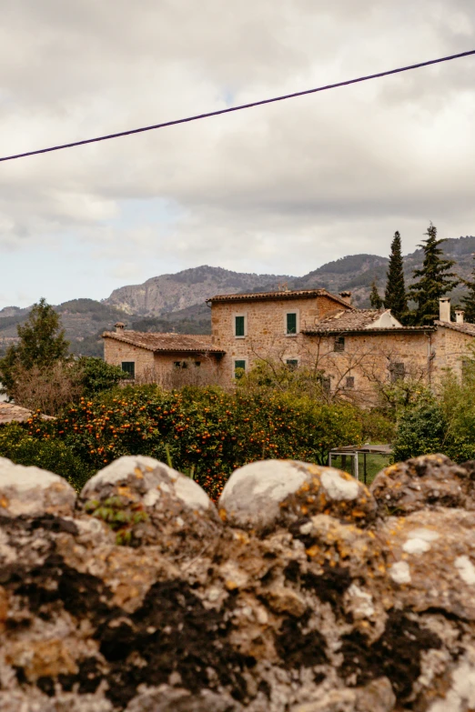 a view of a small stone building with trees in the background