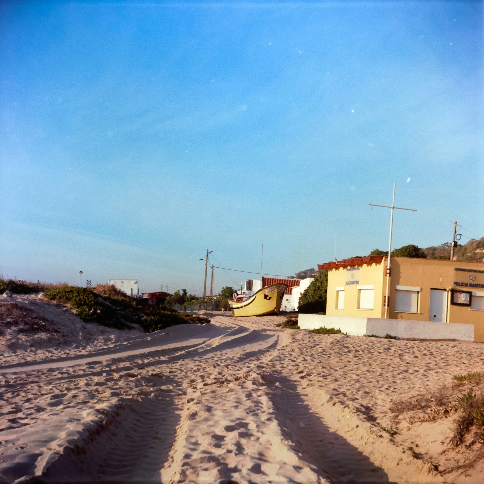 a sandy beach covered in footprints next to a building