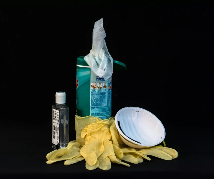 white gloves sitting next to a bottle of cleaner