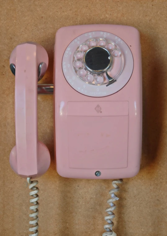 a pink phone with a on and receiver