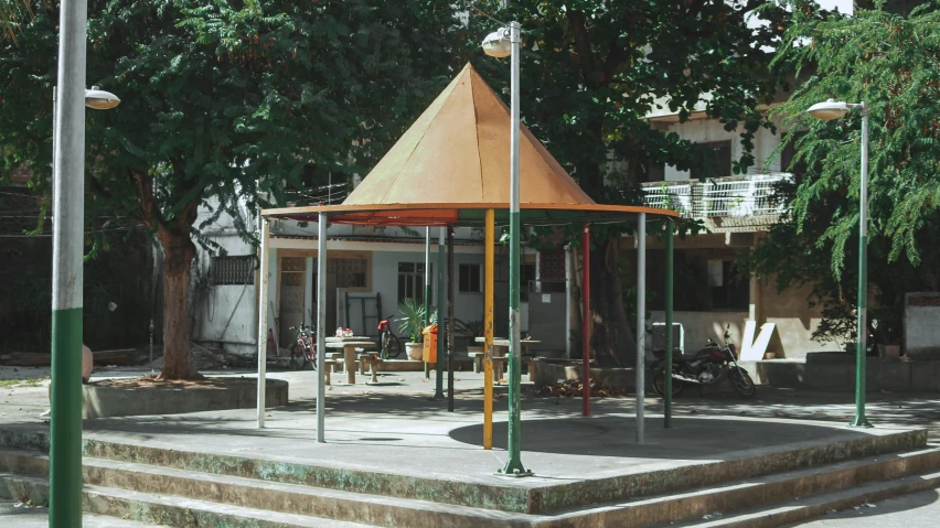 a gazebo stands outside in front of some trees