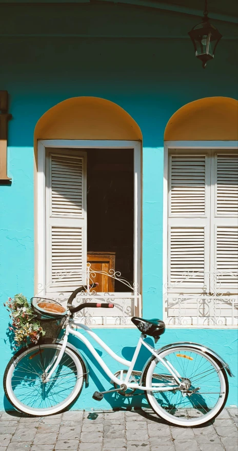 the white bicycle is next to blue building