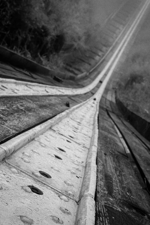 black and white image of a city street with tracks