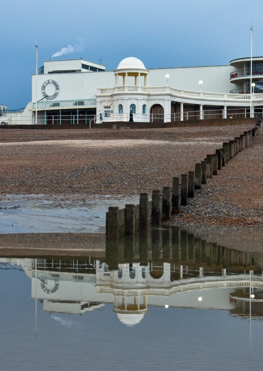 the reflection of a building on the water is in the foreground