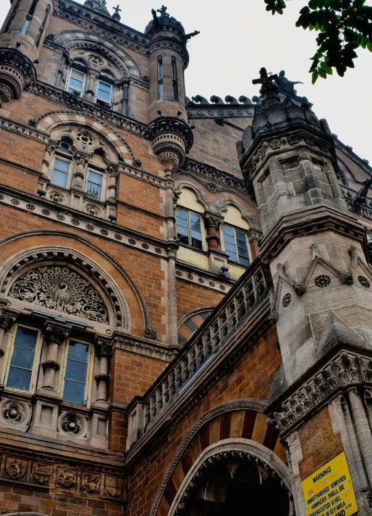 the tower building has ornate architecture and is made of brown bricks