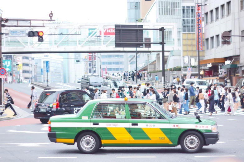 many people are standing in the street near cars