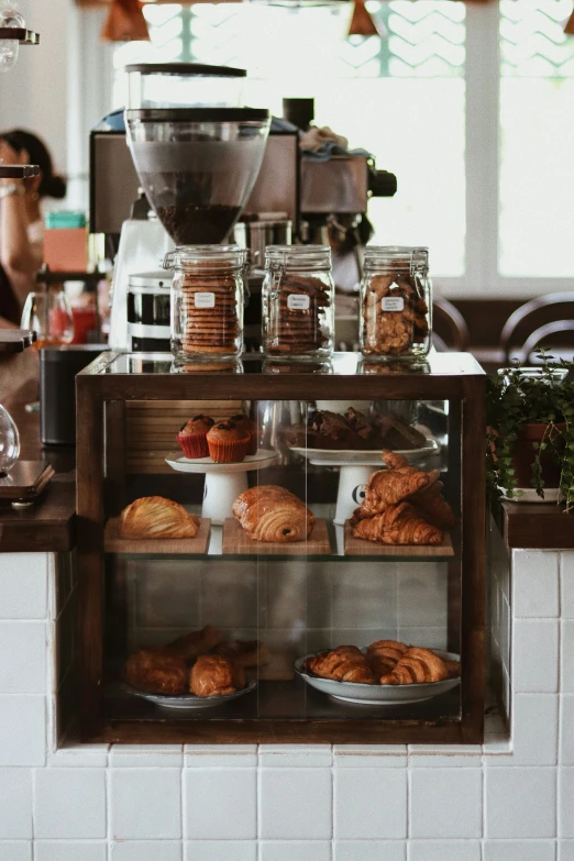 the counter of an upscale coffee shop has pastries and donuts on display