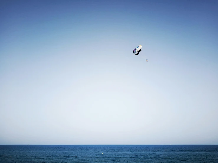 a view of the ocean with a kite flying in the sky