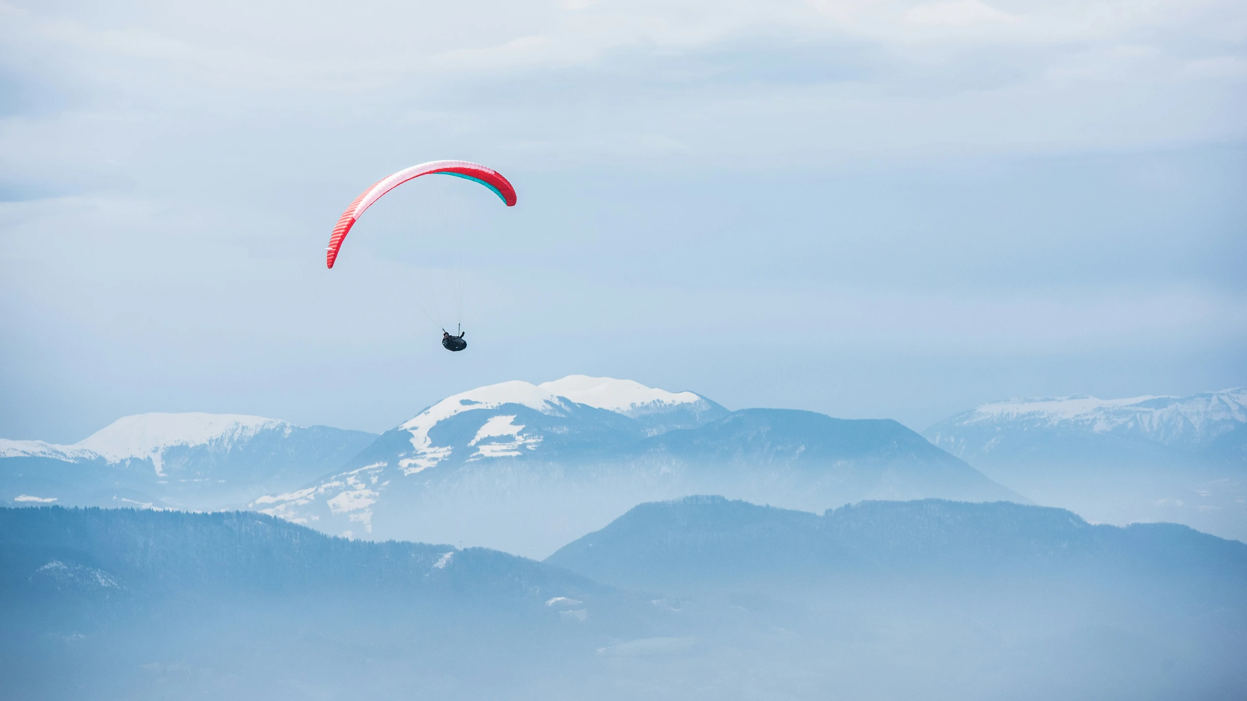 an person on a para sail above the mountains