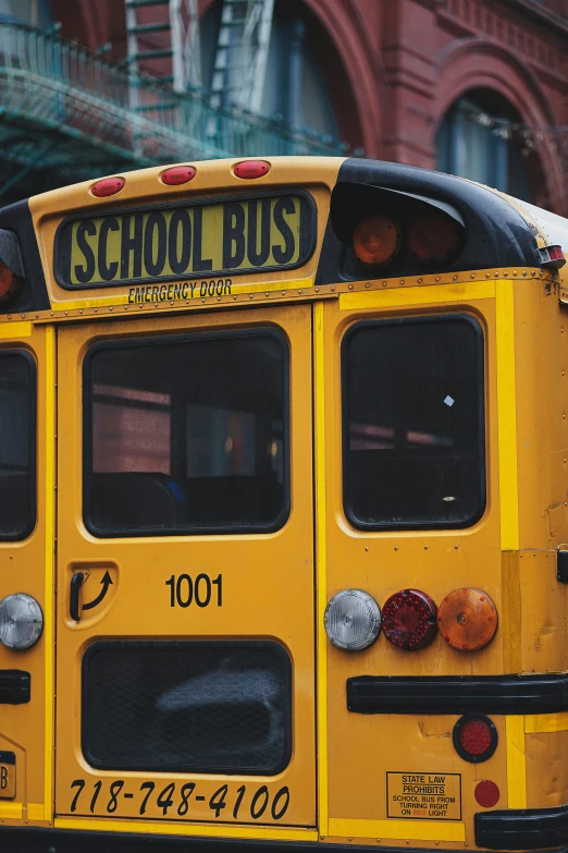 yellow school bus parked in front of an old red brick building