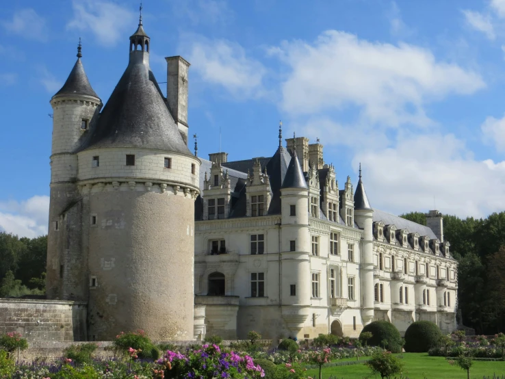 an old castle with flowers on the front lawn