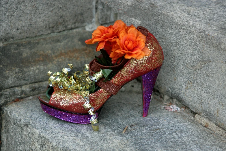 a shoe with a flower in it on the ground