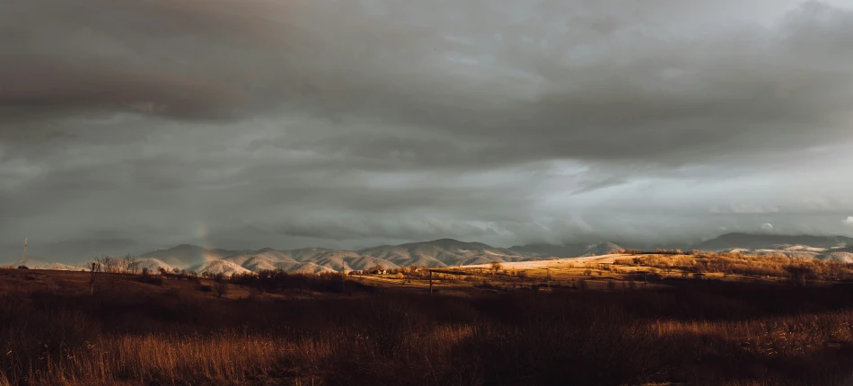 a couple of mountains in the distance with some clouds above