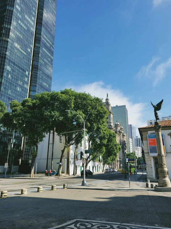 a city street filled with trees next to tall buildings