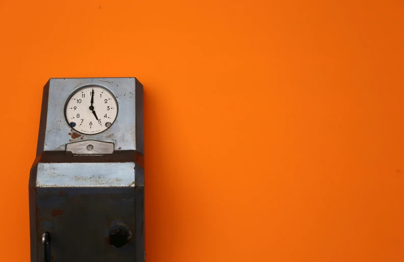 a clock on top of an orange wall