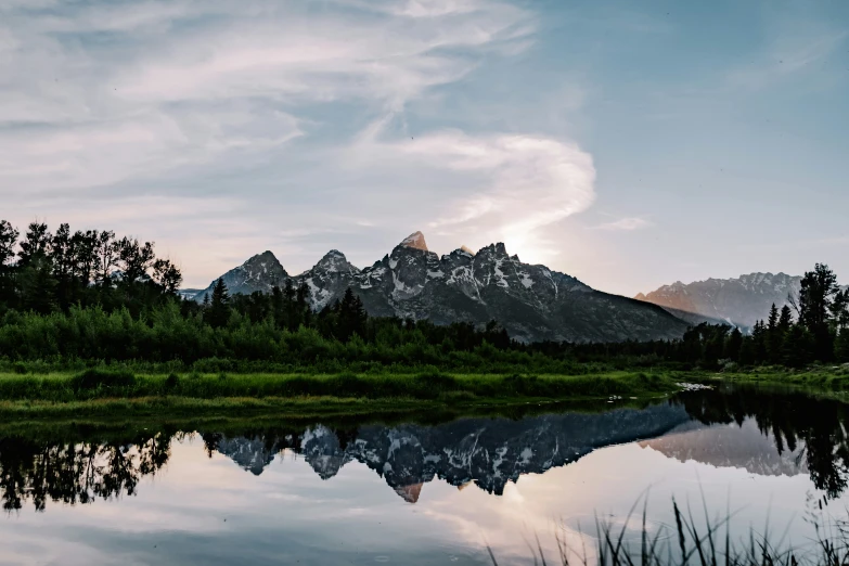 a scenic view of the grand tetons of the mountains from across a lake