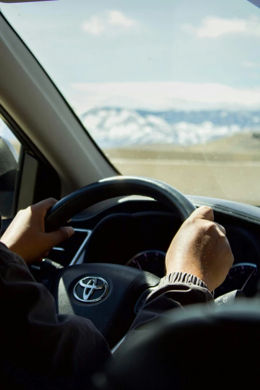 a man is driving a car through the mountains