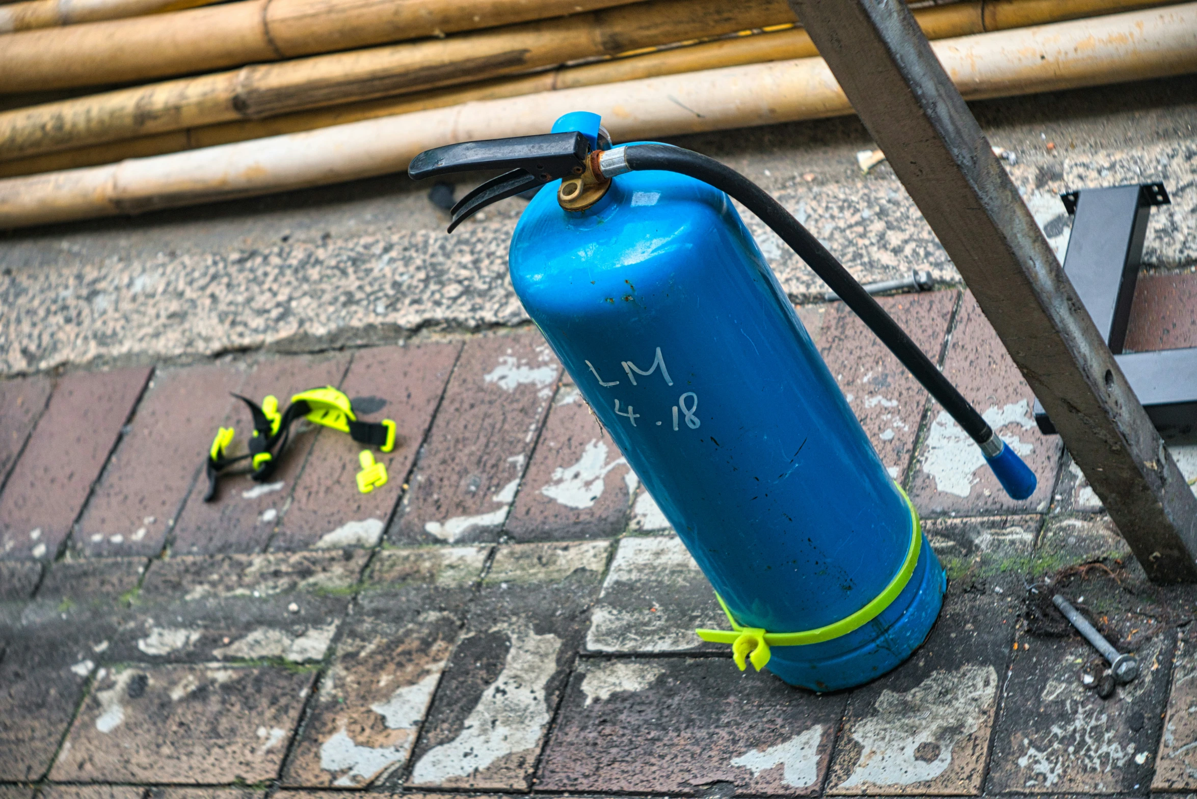 the blue fire extinguisher on the ground with two yellow arrows