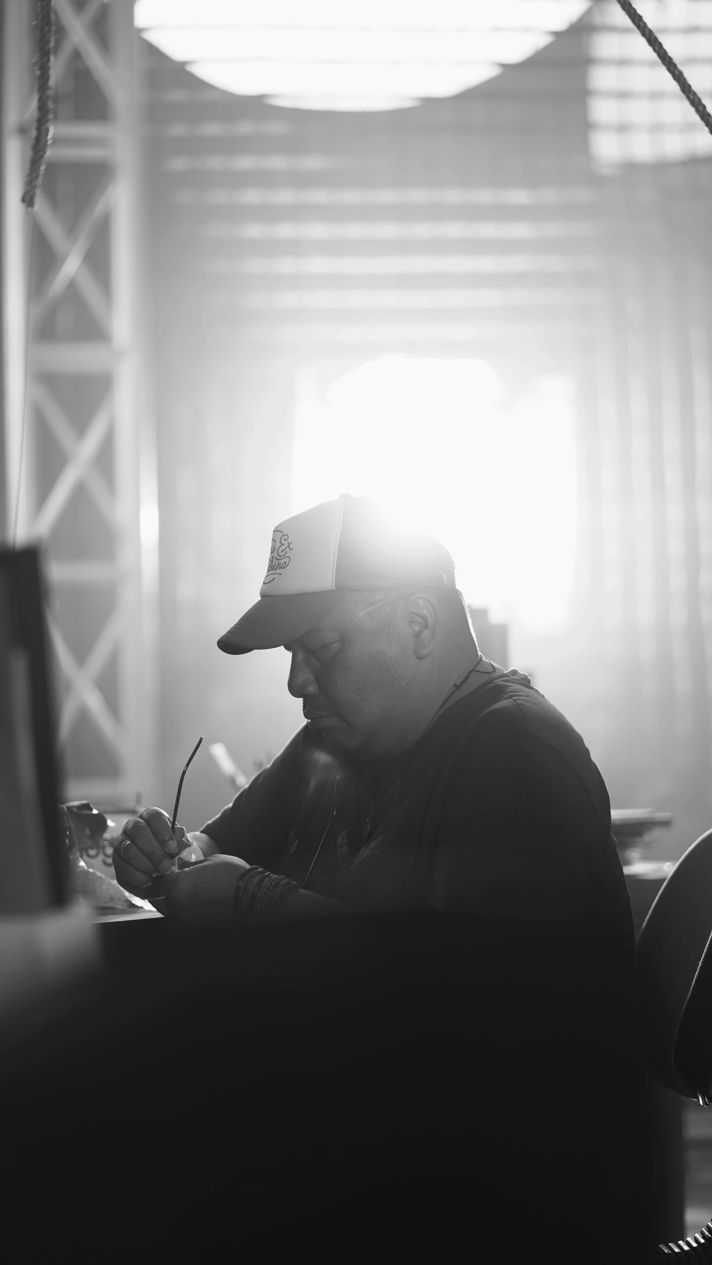 man at desk writing on pen with light streaming through window