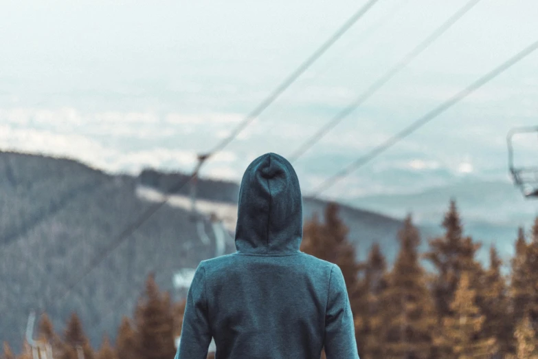 a person standing with skis in hand and mountains in the background