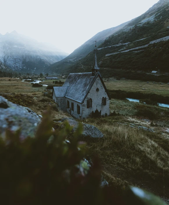 an old church nestled in the middle of some mountains