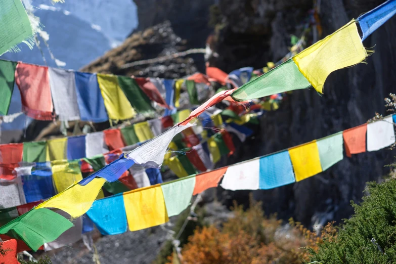 some very pretty flags are hung on the side of a mountain