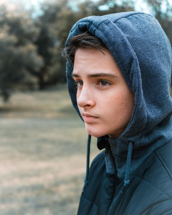 a boy in hoodie looking ahead at soing