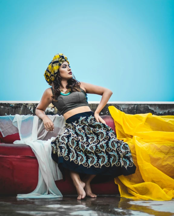a woman wearing an african dress in front of a couch