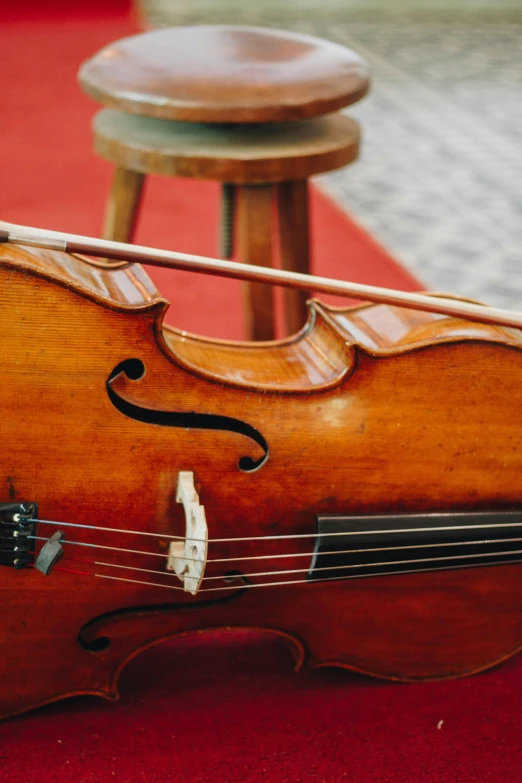 a violin laying down on a red carpeted area