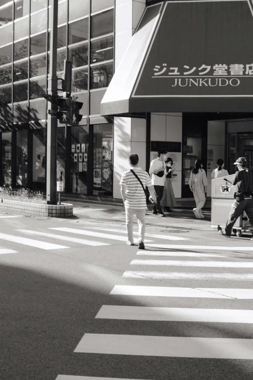 several people are waiting on a cross walk