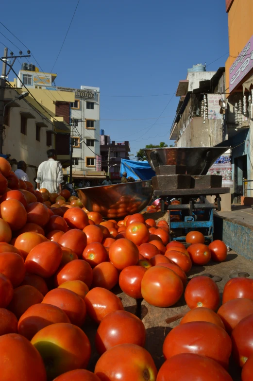 tomatoes in a pile and a truck outside a building