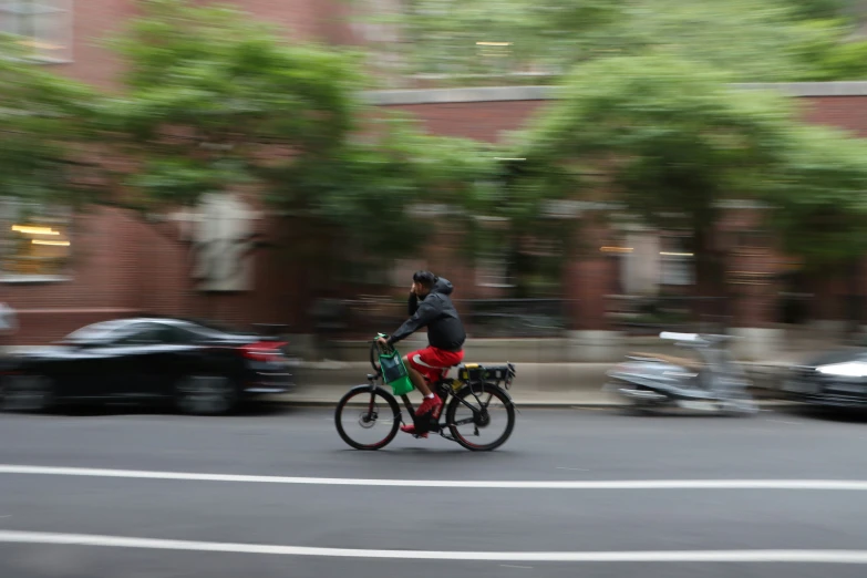 man in helmet with large helmet riding a bike down the street