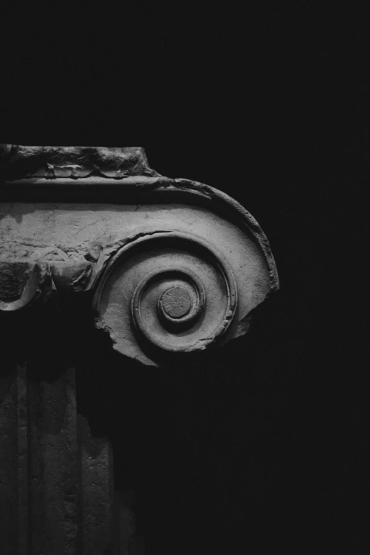 the close up view of an old, crumbling column in the dark