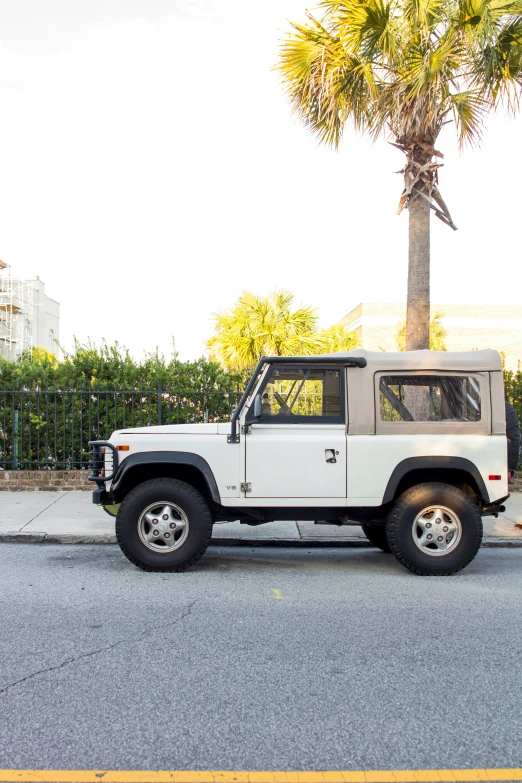 a white four door suv parked on the side of the road