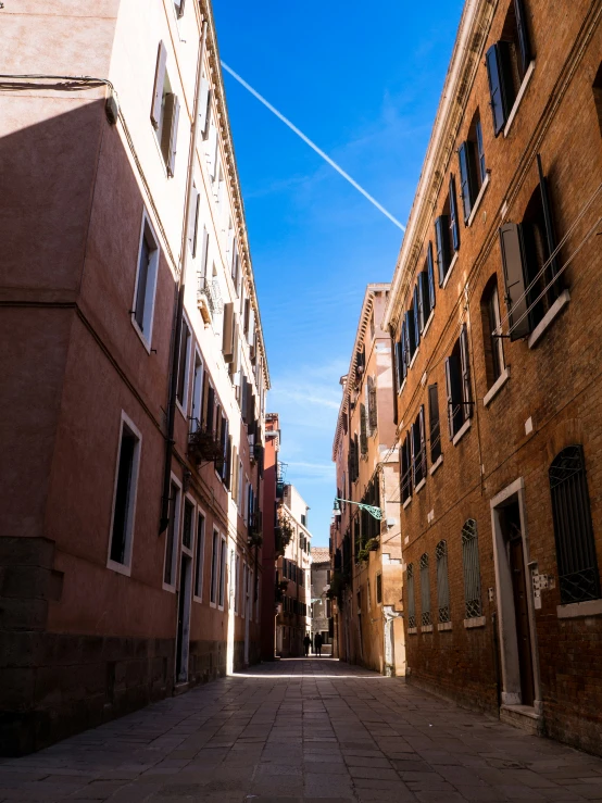 a sidewalk near two old buildings with windows