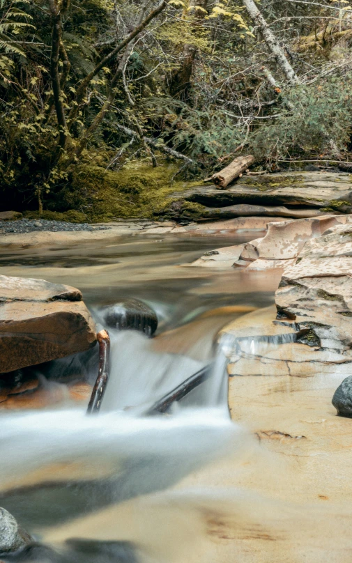 there are rocks and water flowing from the stream