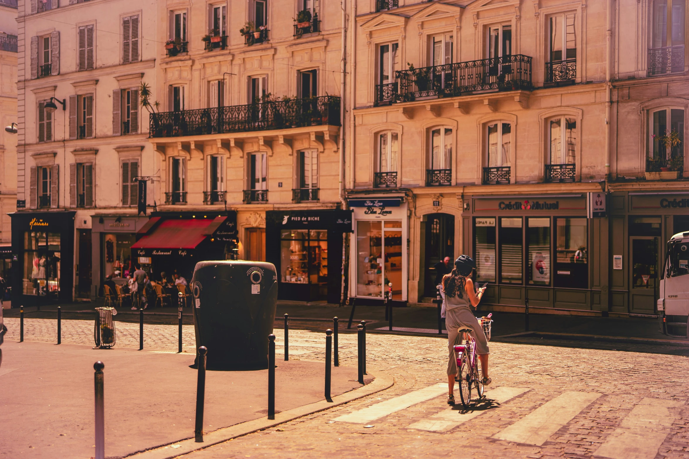 two people on bicycles near a bus parked on the side of a road