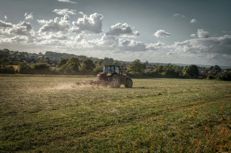 a tractor is on the farm as it moves across the grass