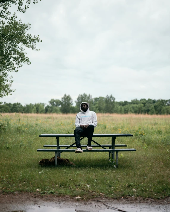 a man sitting on top of a wooden bench