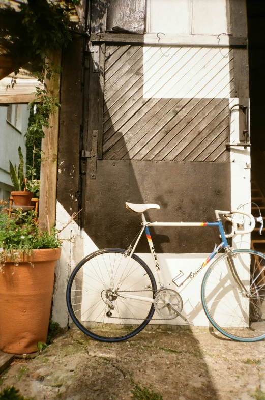 a bicycle  to a door of an old building