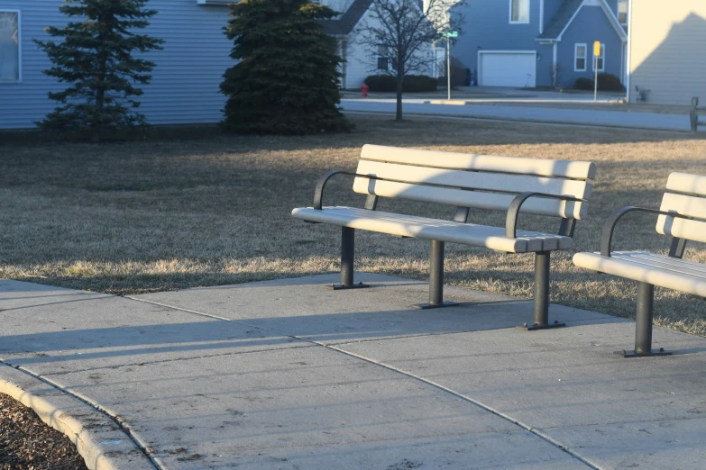 some benches sit on concrete in front of houses