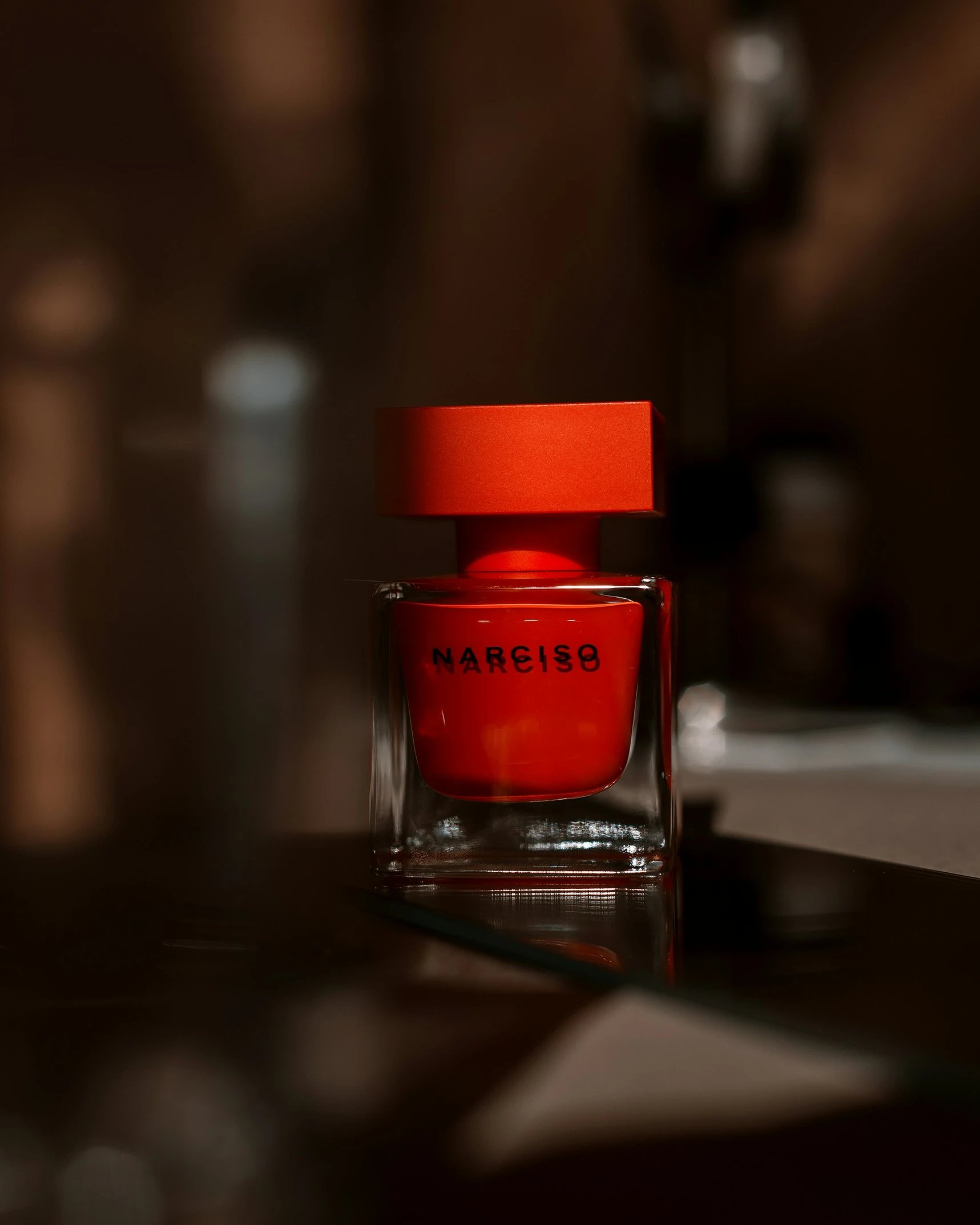 a bright orange and red jar on a dark surface