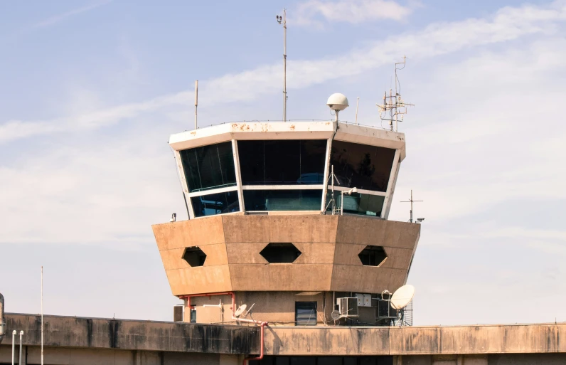 the large brown air traffic control tower in the daytime