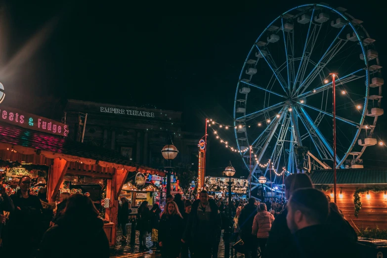 a crowd is gathered near a ferris wheel