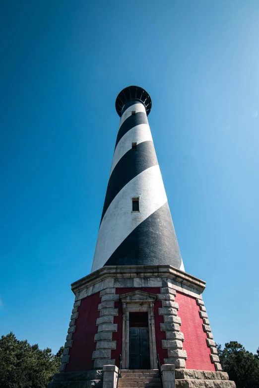 a lighthouse stands tall against a blue sky