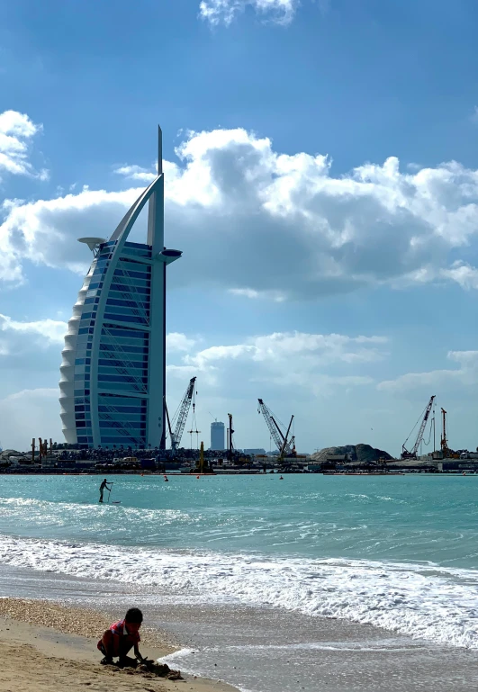 a boy playing on the beach next to the building