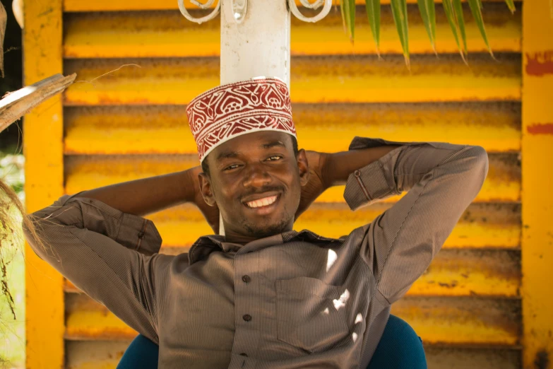 a smiling man with an interesting hat on his head