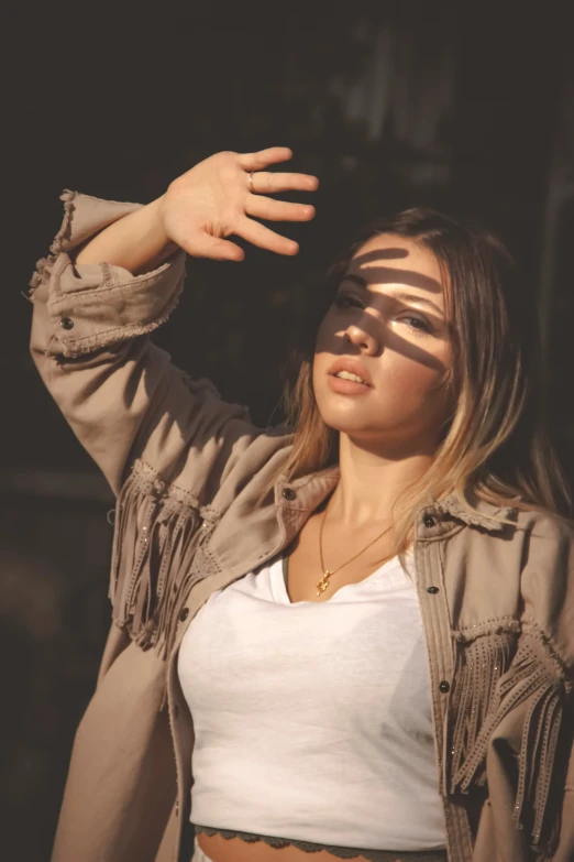 a girl wearing sun glasses while she holds her hand up