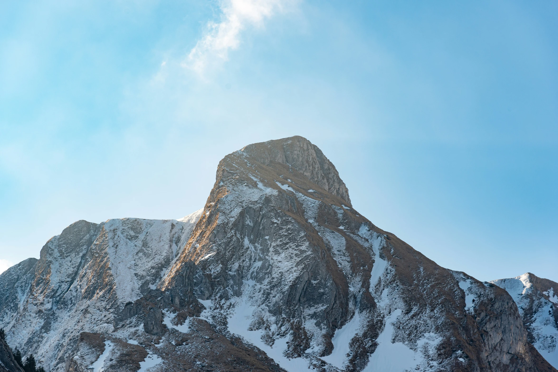 a large mountain covered in snow and clouds