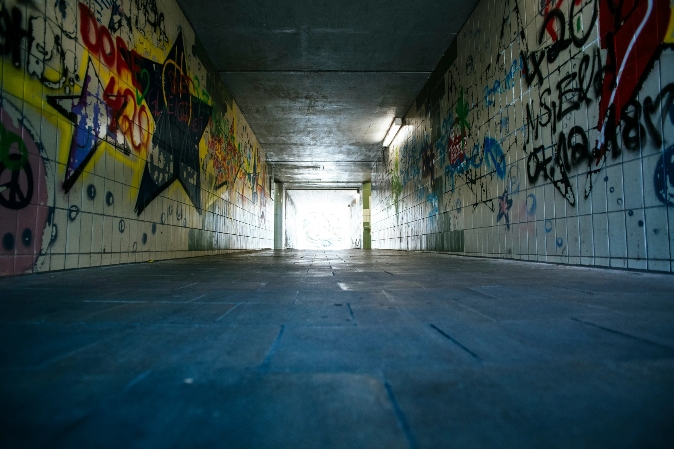 an alleyway with graffiti written all over it